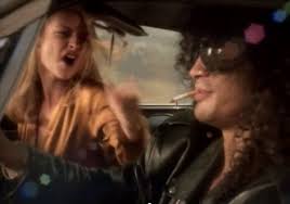 Still from the GnR video. At one point, the model puts her feet in Slash's face, which I think is almost worse than driving them off a cliff.